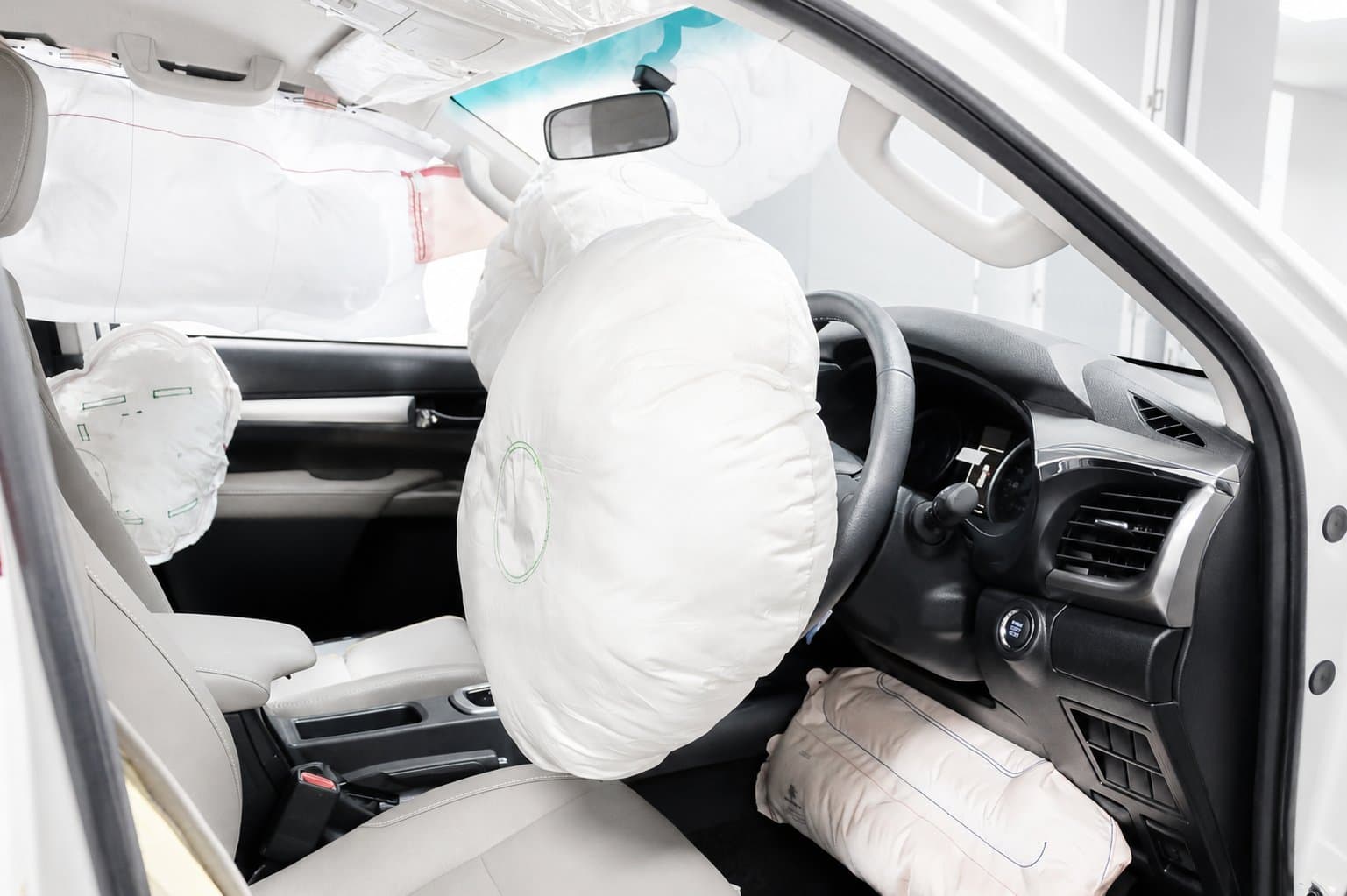 Driver area with deployed steering-wheel, knee and curtain airbags